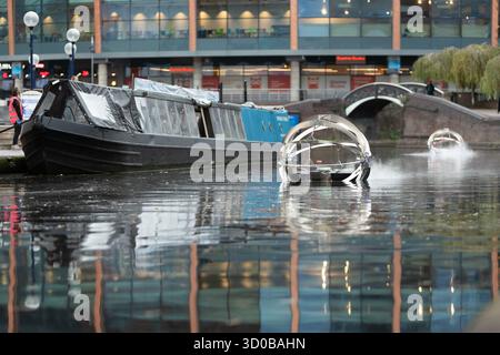 Birmingham, Großbritannien. Oktober 2025. Eine faszinierende Flotte von drei beleuchteten Badeskulpturen, die über die Kanäle von Birmingham und dem Black Country aufführen werden, lässt ihr Mädchen heute im Kanal im Stadtzentrum von Birmingham „schwimmen“. Der Künstler Michael Candy hat Water Bots als bahnbrechende Fusion von Kunst und Technik geschaffen. Es ist vom industriellen Erbe der Region West Midland inspiriert und wurde von Birmingham Open Media in Auftrag gegeben. Quelle: Peter Lopeman/Alamy Live News Stockfoto