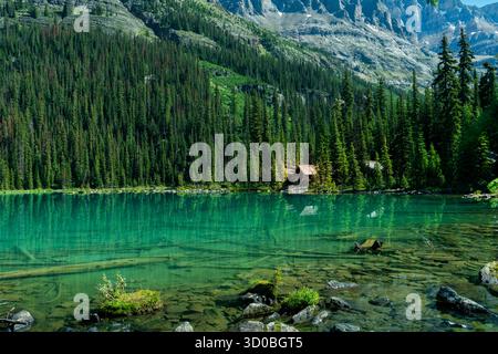 Malerischer Blick auf einen unberührten See, der den umliegenden Wald und die Berge reflektiert. Ohara Lake, BC Stockfoto