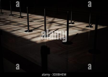 Washington, Usa. Oktober 2025. Licht scheint durch das Oberlicht auf Standrohre, die leere Linien im Capitol Visitors Center bilden. Am 22. Oktober 2025 in Washington, DC, ist die Schließung der US-Regierung inzwischen die zweitlängste in der Geschichte der USA geworden und liegt hinter der 35-tägigen Abschaltung während der ersten Amtszeit von Präsident Trumps, die 2018 begann und bis 2019 lief. (Foto: Samuel Corum/SIPA USA) Credit: SIPA USA/Alamy Live News Stockfoto