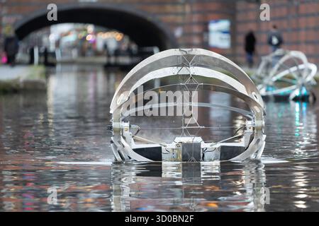 Birmingham, Großbritannien. Oktober 2025. Eine faszinierende Flotte von drei beleuchteten Badeskulpturen, die über die Kanäle von Birmingham und dem Black Country aufführen werden, lässt ihr Mädchen heute im Kanal im Stadtzentrum von Birmingham „schwimmen“. Der Künstler Michael Candy hat Water Bots als bahnbrechende Fusion von Kunst und Technik geschaffen. Es ist vom industriellen Erbe der Region West Midland inspiriert und wurde von Birmingham Open Media in Auftrag gegeben. Quelle: Peter Lopeman/Alamy Live News Stockfoto