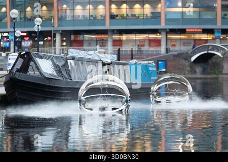 Birmingham, Großbritannien. Oktober 2025. Eine faszinierende Flotte von drei beleuchteten Badeskulpturen, die über die Kanäle von Birmingham und dem Black Country aufführen werden, lässt ihr Mädchen heute im Kanal im Stadtzentrum von Birmingham „schwimmen“. Der Künstler Michael Candy hat Water Bots als bahnbrechende Fusion von Kunst und Technik geschaffen. Es ist vom industriellen Erbe der Region West Midland inspiriert und wurde von Birmingham Open Media in Auftrag gegeben. Quelle: Peter Lopeman/Alamy Live News Stockfoto