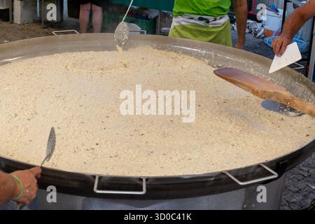 Kochen von Risotto mit Gorgonzola cremigem Blauschimmelkäse in einer riesigen Pfanne auf dem lokalen Festival in Gorzonzola Stadt, Lombardei, Italien Stockfoto
