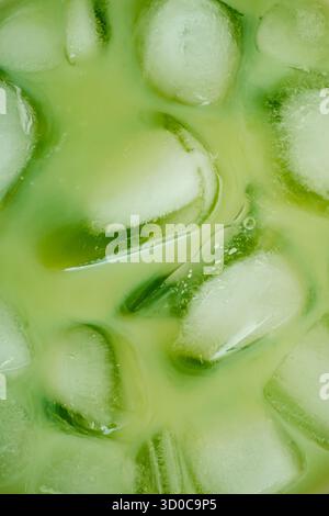 Nahaufnahme von geeistem grünem Matcha-Tee. Kreatives trendiges gesundes Getränk Hintergrundkonzept. Matcha Textur Hintergrund Idee. Flacher Style. Banner mit Draufsicht. Stockfoto