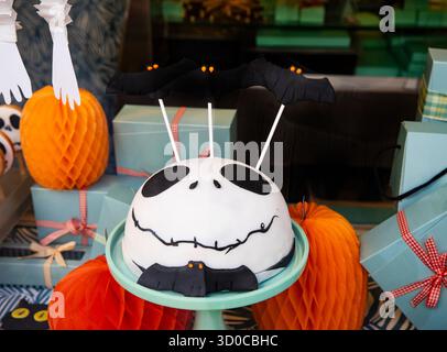 Desserttisch für Feiertage mit Süßigkeiten und blauen und orangen Schachteln. Jack Skellington Fledermauskuchen für Halloween-Dekoration Stockfoto