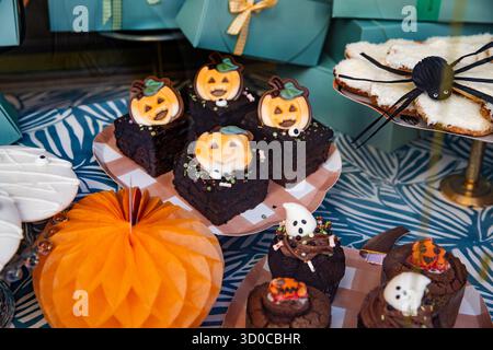 Brownies und Kekse auf einem Stock, dekoriert mit Kürbissen und Spinnen für Halloween. Halloween Desserttisch Stockfoto