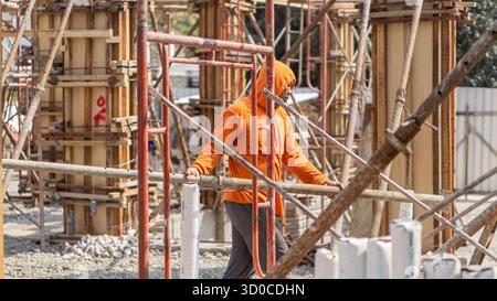 Ein Bauarbeiter, der auf der Baustelle aktiv ist und im Bauprozess Engagement und Präzision zeigt. Stockfoto