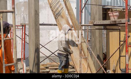 Ein Bauarbeiter, der auf der Baustelle aktiv ist und im Bauprozess Engagement und Präzision zeigt. Stockfoto
