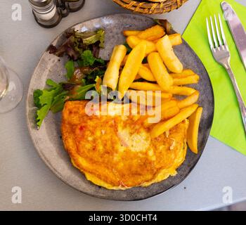Portion Gourmet-Omelett mit gebratenen Kartoffeln Stockfoto