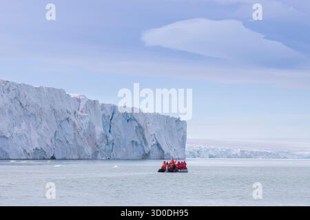 Touristen in einem Schlauchboot am Brasvellbreen-Gletscher auf der Austfonna-Eiskappe, Svalbard, Norwegen Stockfoto