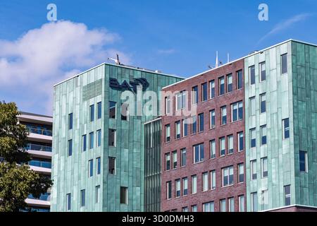 British American Tobacco Hauptsitz in Amstelveen, Niederlande, mit grüner Metallfassade, rotem Backsteindesign und moderner Geschäftsarchitektur. A Stockfoto