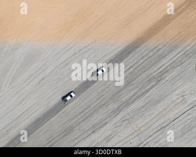 Aus der Luft, Blick von oben, zwei Geländewagen fahren auf einer Straße in der trockenen Landschaft, Botswana Stockfoto