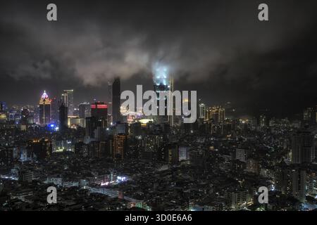Panoramablick auf Taipeh 101 und umliegende Gebäude bei Nacht während eines Regensturms. Berühmter ikonischer Wolkenkratzer in Taiwan Stockfoto