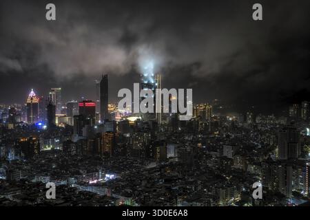 Panoramablick auf Taipeh 101 und umliegende Gebäude bei Nacht während eines Regensturms. Berühmter ikonischer Wolkenkratzer in Taiwan Stockfoto