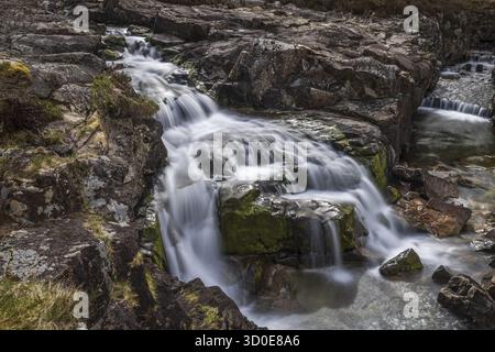 Der Fluss Coe entspringt am nordöstlichen Fuß des Buachaille Etive Beag in Schottland und fließt entlang des Glen Coe nach Westen. Nach dramatischen Wasserfällen am Pas Stockfoto