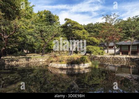 Ein kleiner Schrein in der Nähe des Eingangs mit den Reflexionen auf dem Teichwasser. Aufgenommen in Jongmyo, Seoul, Südkorea Stockfoto