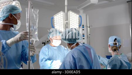 Team von vier Ärzten in blauen Kleidern operiert am Patienten im Krankenhaus ODER mit chirurgischen Werkzeugen. Chirurgenteam, Mediziner, Assistenten, Hospi Stockfoto