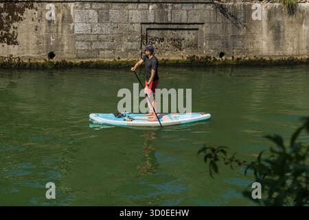 Ljubljana, Slowenien August 10-2025 urbanes Paddeln, Stand Up Paddler auf dem Fluss ljubljanica slowenien in der Nähe der Dreierbrücke und der Stadtmitte Stockfoto