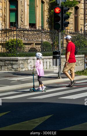 Ljubljana, Slowenien August 10-2025 Fußgängerüberquerung mit Erwachsenen und Kindern, Fußgängerüberquerung mit roter Ampel Stockfoto