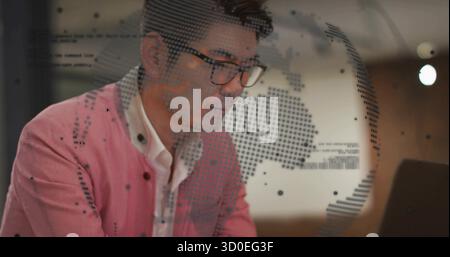 Analyse der Datenüberlagerung auf einem Laptop durch asiatische Büroangestellte, die am Schreibtisch einen pinken Blazer tragen, im Kopierraum Stockfoto