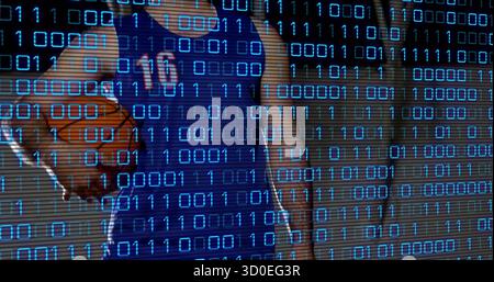 Mann trägt blaues Trikot Nummer 10, der Basketball im Fitnessstudio hält, mit Binärcode-Overlay Stockfoto