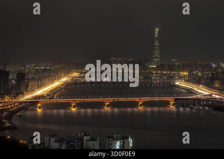 Nächtlicher Blick über den Fluss han auf dem Gipfel des Aussichtspunkts Eungbongsan Mountain. In der Ferne befindet sich der lotte Tower in Seoul, Südkorea Stockfoto