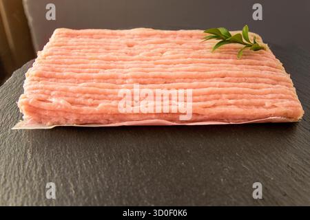 Frisches Hähnchenhack auf schwarzer Steinoberfläche, Naturprodukt für gesundes Kochen Stockfoto
