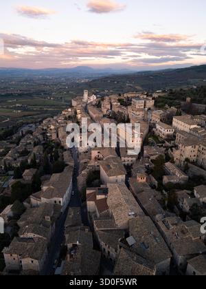 Blick aus der Vogelperspektive auf Assisis alte Straßen und die Basilika di San Francesco im sanften Glanz der untergehenden Sonne, Assisi, Umbrien, Italien. Stockfoto