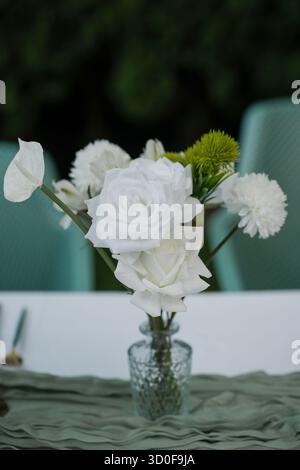 Herzstück mit frischen weißen Rosen, Nelken, Chrysanthemen und Anthurium, akzentuiert mit einem Hauch von grünem Laub, wunderschönes Arrangement Stockfoto
