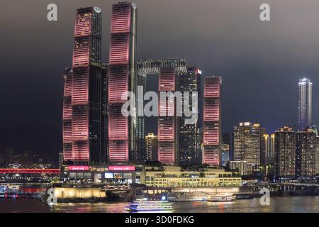 Aus der Vogelperspektive des Raffles City Chongqing Complex, beleuchtet mit lebhaften Farbtönen, reflektiert im dunklen Wasser darunter, Chongqing, Chongqing, China. Stockfoto