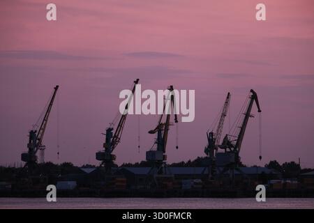 Silhouetten der Wharf Krane Vor Sonnenuntergang Himmel Stockfoto
