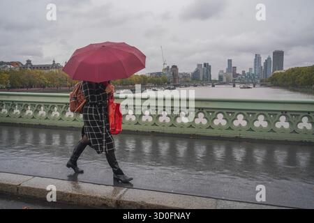 Am 23. Oktober 2025 überwindet Fußgänger starke Winde vom Sturm Benjamin auf der Westminster Bridge Stockfoto