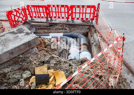Verlegung neuer Wasserrohre mit großem Durchmesser in den Boden in der Stadt. Stockfoto
