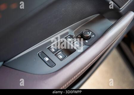 Schwarzer Kunststoff, elektrische Fensterheber an einer Türarmlehne. Nahaufnahme, von oben nach unten, keine Leute. Stockfoto