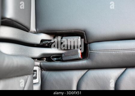 Die Gurtschlösser der neuen Pkw-Rücksitze werden ordentlich in der Einbuchtung der Sitzbank verstaut. Top-Down, Nahaufnahme, keine Leute Stockfoto
