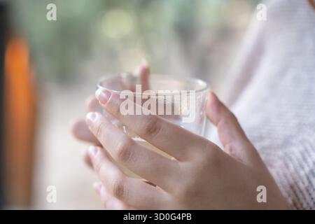 Frau in Gläsern, die besinnt, eine warme Tasse Kräutertee genießt Stockfoto