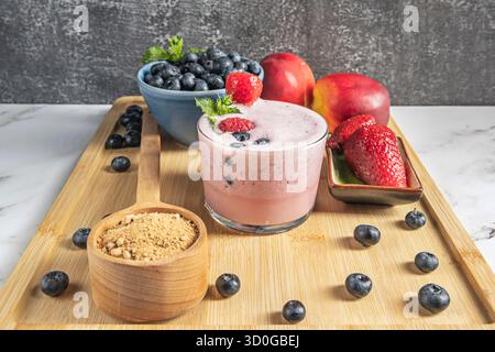 Violette Heidelbeeren und ein Heidelbeeren- und Chiasamen-Smoothie auf einer Buchenholzoberfläche Stockfoto