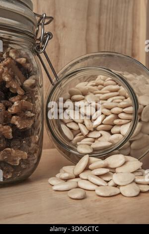 Komposition mit hausgemachten karamelisierten Mandeln, Malaga-Rosinen, ausgewählten Schmetterlingsnüssen und Goji-Beeren auf einer Holzoberfläche Stockfoto