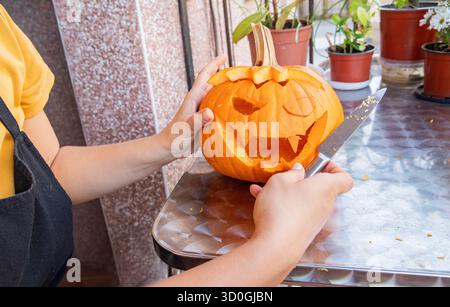 Nahaufnahme einer Person, die Jack o Laterne hält. Halloween Deko Kürbisgesicht Stockfoto