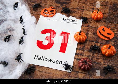 Bayern, Deutschland - 23. Oktober 2025: FOTOMONTAGE, Eine Kalenderseite zeigt Oktober 31 mit der Inschrift: Halloween, dekoriert mit kleinen Kürbissen, Spinnen und Spinnweben als Symbol des beliebten gruseligen Festivals *** FOTOMONTAGE, ein Kalenderblatt zeigt den 31. Oktober mit der Aufschrift: Halloween, dekoriert mit kleinen Kürbissen, Spinnen und Spinnweben als Symbol für das beliebte Gruselfest Stockfoto