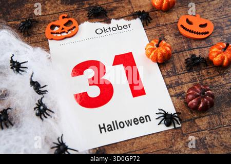 Bayern, Deutschland - 23. Oktober 2025: FOTOMONTAGE, Eine Kalenderseite zeigt Oktober 31 mit der Inschrift: Halloween, dekoriert mit kleinen Kürbissen, Spinnen und Spinnweben als Symbol des beliebten gruseligen Festivals *** FOTOMONTAGE, ein Kalenderblatt zeigt den 31. Oktober mit der Aufschrift: Halloween, dekoriert mit kleinen Kürbissen, Spinnen und Spinnweben als Symbol für das beliebte Gruselfest Stockfoto