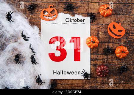 Bayern, Deutschland - 23. Oktober 2025: FOTOMONTAGE, Eine Kalenderseite zeigt Oktober 31 mit der Inschrift: Halloween, dekoriert mit kleinen Kürbissen, Spinnen und Spinnweben als Symbol des beliebten gruseligen Festivals *** FOTOMONTAGE, ein Kalenderblatt zeigt den 31. Oktober mit der Aufschrift: Halloween, dekoriert mit kleinen Kürbissen, Spinnen und Spinnweben als Symbol für das beliebte Gruselfest Stockfoto