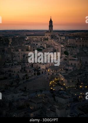 Aus der Vogelperspektive erstrahlen antike Steinhäuser sanft unter dem schwindenden Licht, gekrönt vom majestätischen Dom, einer zeitlosen Szene der Geschichte und Gelassenheit, Ma Stockfoto