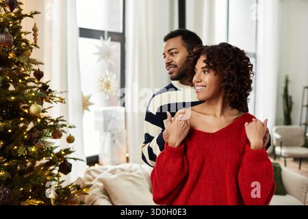 Zwei Personen feiern Weihnachten fröhlich zusammen in festlicher Dekoration in ihrem Haus. Stockfoto