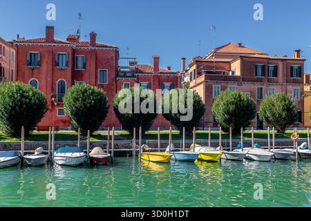 Elegante Gebäude hinter kleinen Booten, die am rio de Sant Elena, einem ruhigen Kanal, der an Sant Elena und das Castello Sestieri von Venedig, Italien, grenzt, vor Anker liegen Stockfoto