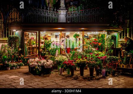 Menschen, die Blumen aus Angolo Fiorito kaufen, einem Blumengeschäft oder Blumenladen in Campo San Vidal bei Nacht im San Marcio Sestieri von Venedig, Italien Stockfoto