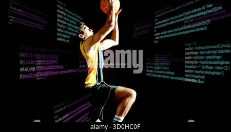 Springender Athlet, der im dunklen Studio Basketball schießt, trägt gelbes Trikot, schwimmende Codetafeln Stockfoto