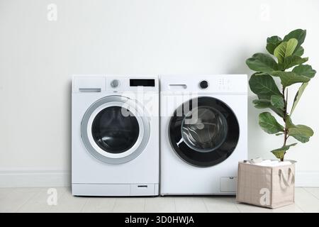 Waschmaschine und Wäschetrockner im geräumigen Waschraum Stockfoto