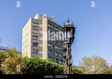 Prunkvolle Straßenlaterne vor dem modernen Apartmentgebäude unter klarem blauem Himmel in urbaner Szene Stockfoto