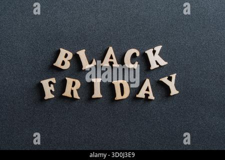 Holzbriefe mit der Aufschrift Black friday auf schwarzem Hintergrund, Nahaufnahme, Draufsicht. Zeit für Promotions und Verkäufe in Geschäften Stockfoto