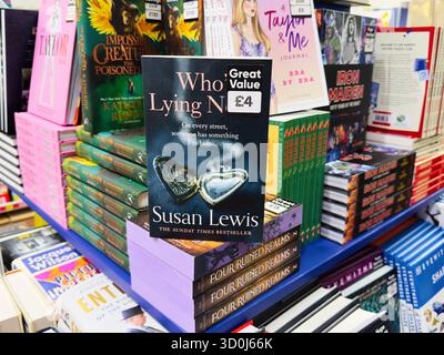 Manchester, UK - 26. September 2025: Who’s Ligen Now von Susan Lewis wird in einer Buchhandlung gezeigt, umgeben von bunten Romanen. Stockfoto